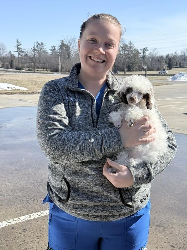 Smiling pet owner holding their dog after safe transport delivery